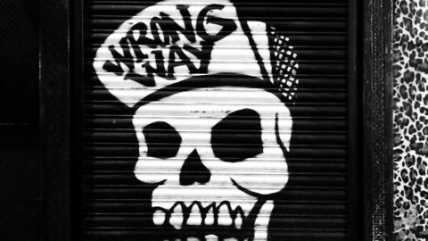 funky skull graffiti on locked roll down black door