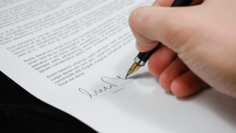 person signing in documentation paper